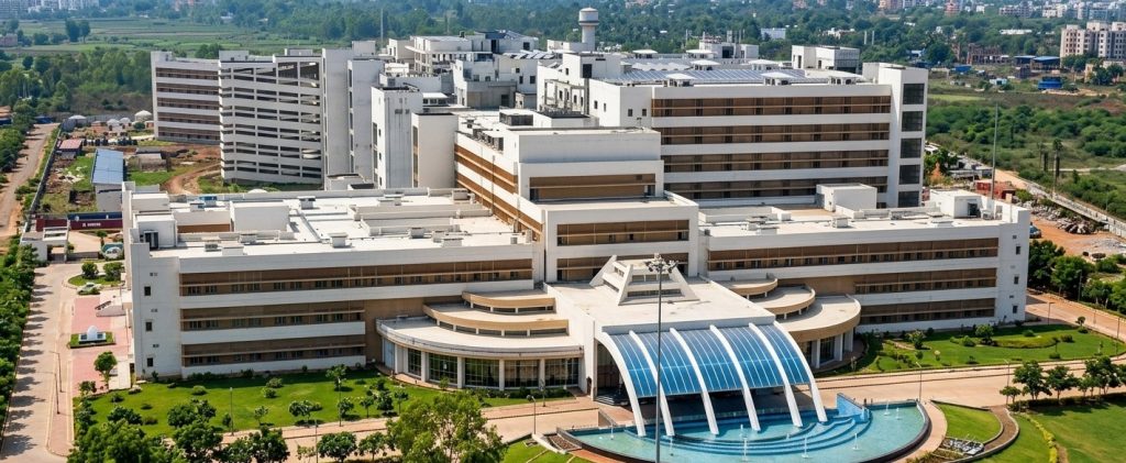 Aerial view of modern medical college and hospital campus with modern architecture, landscaped gardens and big central entrance fountain.